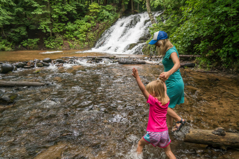 在密歇根州hg6668皇冠登录市的摩根溪瀑布玩耍的妇女和小女孩