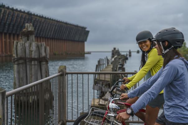 两个女人骑着自行车欣赏下港矿石码头.