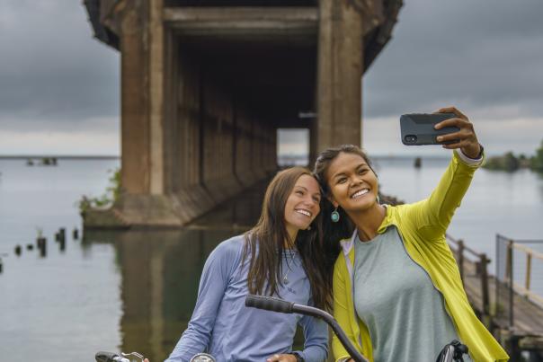 Two friends taking a selfie in front of the Lower Harbor Ore Dock in downtown Marquette