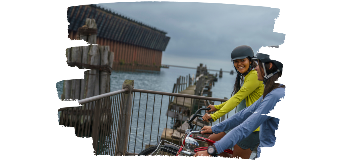 Two women admiring the Lower Harbor Ore Dock on bike.