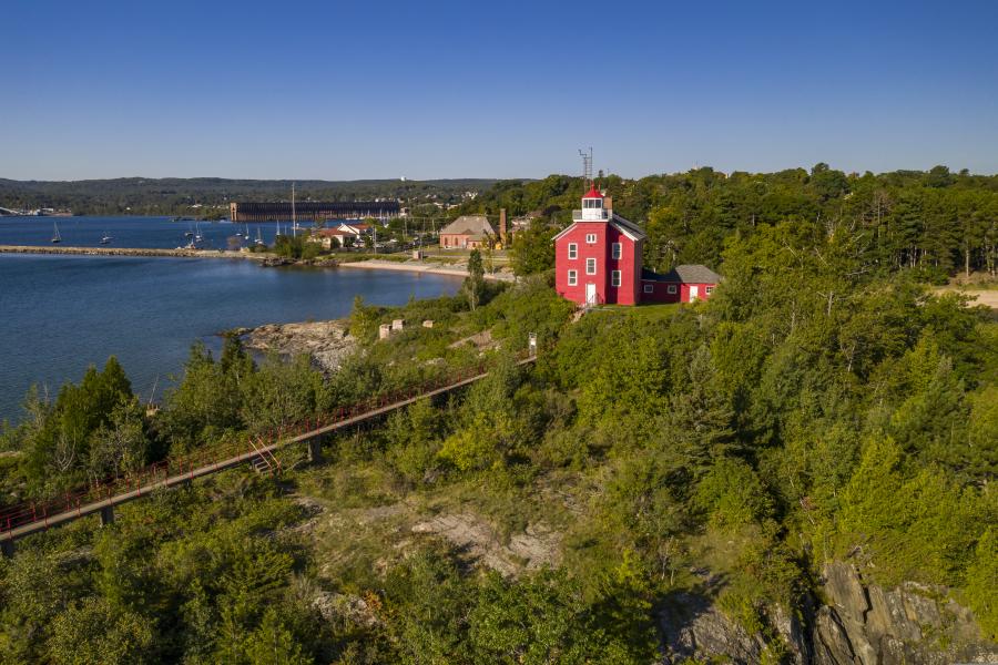 An aerial image of the Marquette Harbor Lighthouse on the rocky coast of Lake Superior.