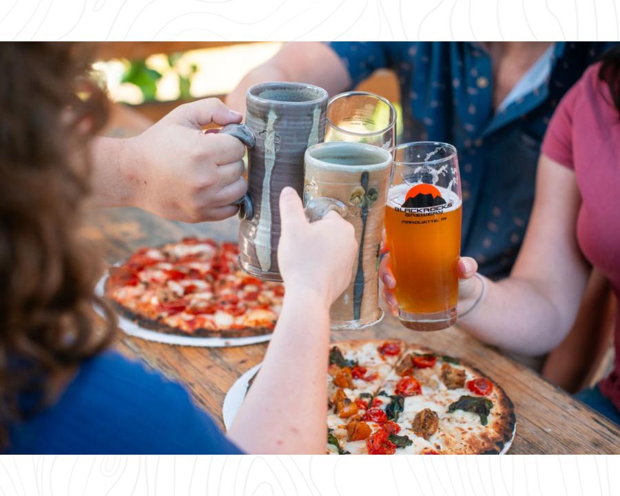 在密歇根州hg6668皇冠登录市的黑岩啤酒厂，朋友们在餐桌上碰杯，吃着柴火披萨