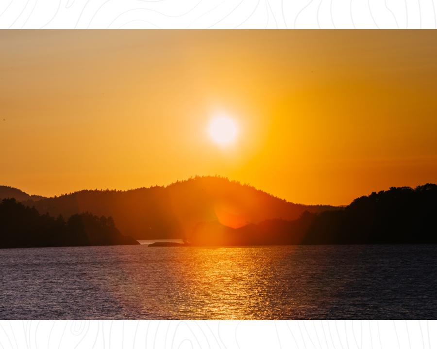 A sunset photo taken from Presque Isle. 一个橙色的天空和大太阳在休伦山下的苏必利尔湖在hg6668皇冠登录，密歇根州