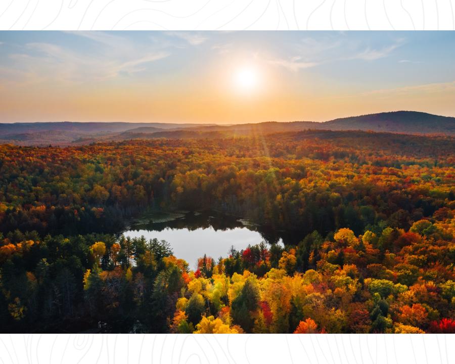 An aerial view of Harlow Lake surrounded by colorful fall foliage in Marquette, MI