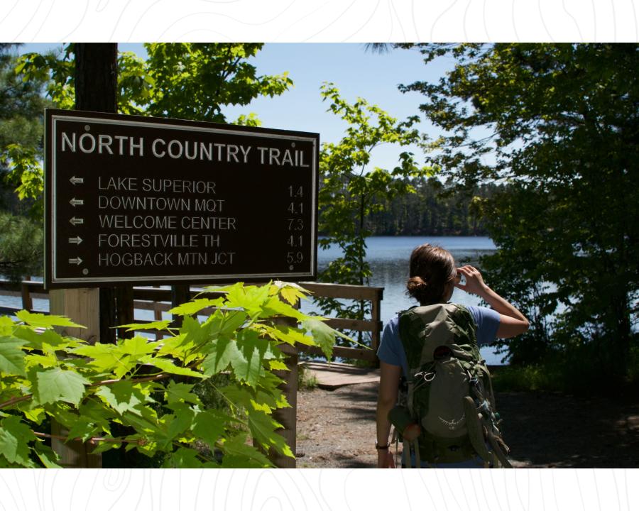 A woman walking on the North Country Trail near the Tourist Park Trailhead in Marquette, MI