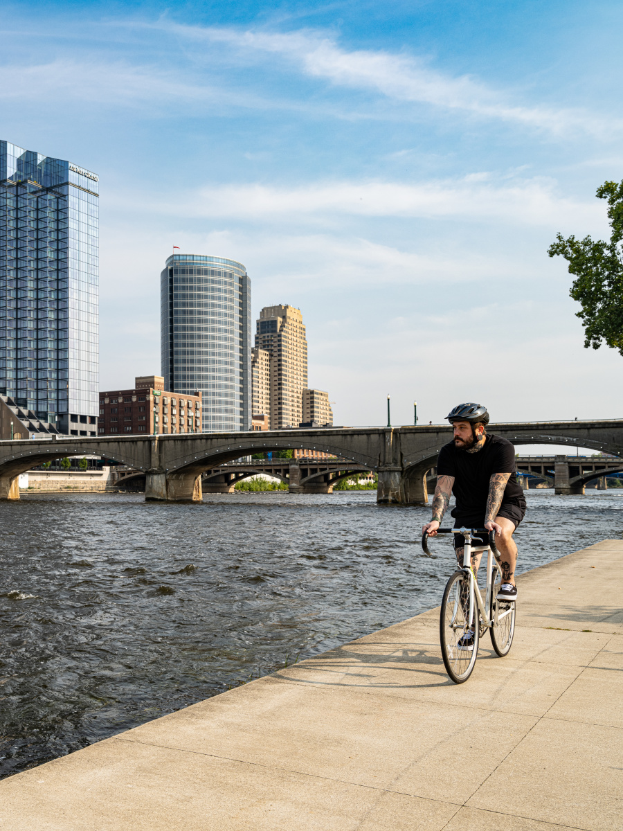 Man riding bike on riverfront.
