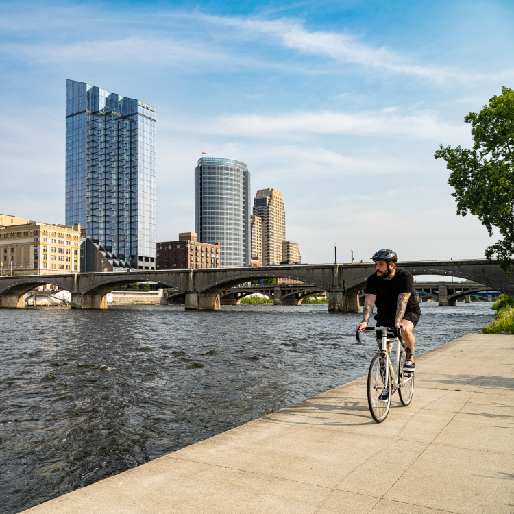 Man riding bike on riverfront.