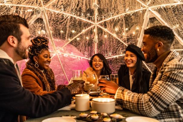 Group at Third Nature enjoying the outdoor space including fire-pits and igloos in the winter.