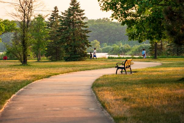 People strolling along the path at Millennium Park surrounded by greenery.