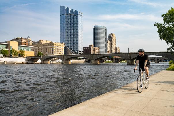 Man riding bike on riverfront.