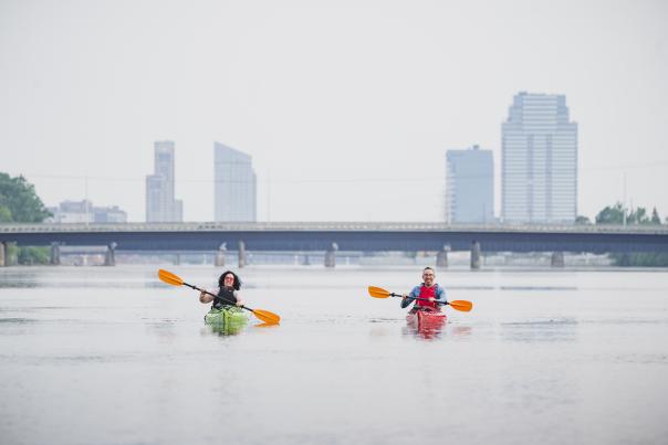 Kayakers paddling away from Downtown Grand Rapids on the Grand River.