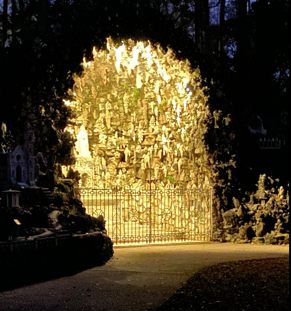 Yellow lights illuminate a religious statue at the Christmas at the Grotto