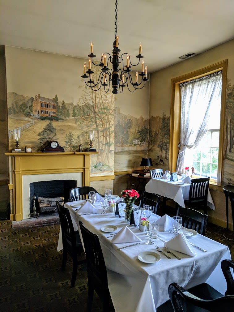 Handpainted murals covering the walls of a dining room in Tousey House Tavern