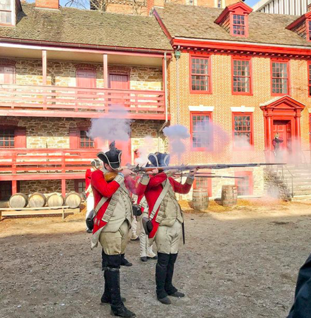 Redcoat reenactors firing their muskets at Old Barracks Museum in Princeton