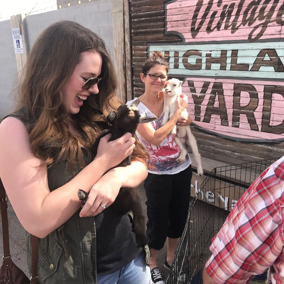 Women hold baby goats at Highland Yard Vintage Market in Chandler, AZ