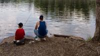 Visitors fish on the calm shores of Laurel Lake at Pine Grove Furnace State Park.