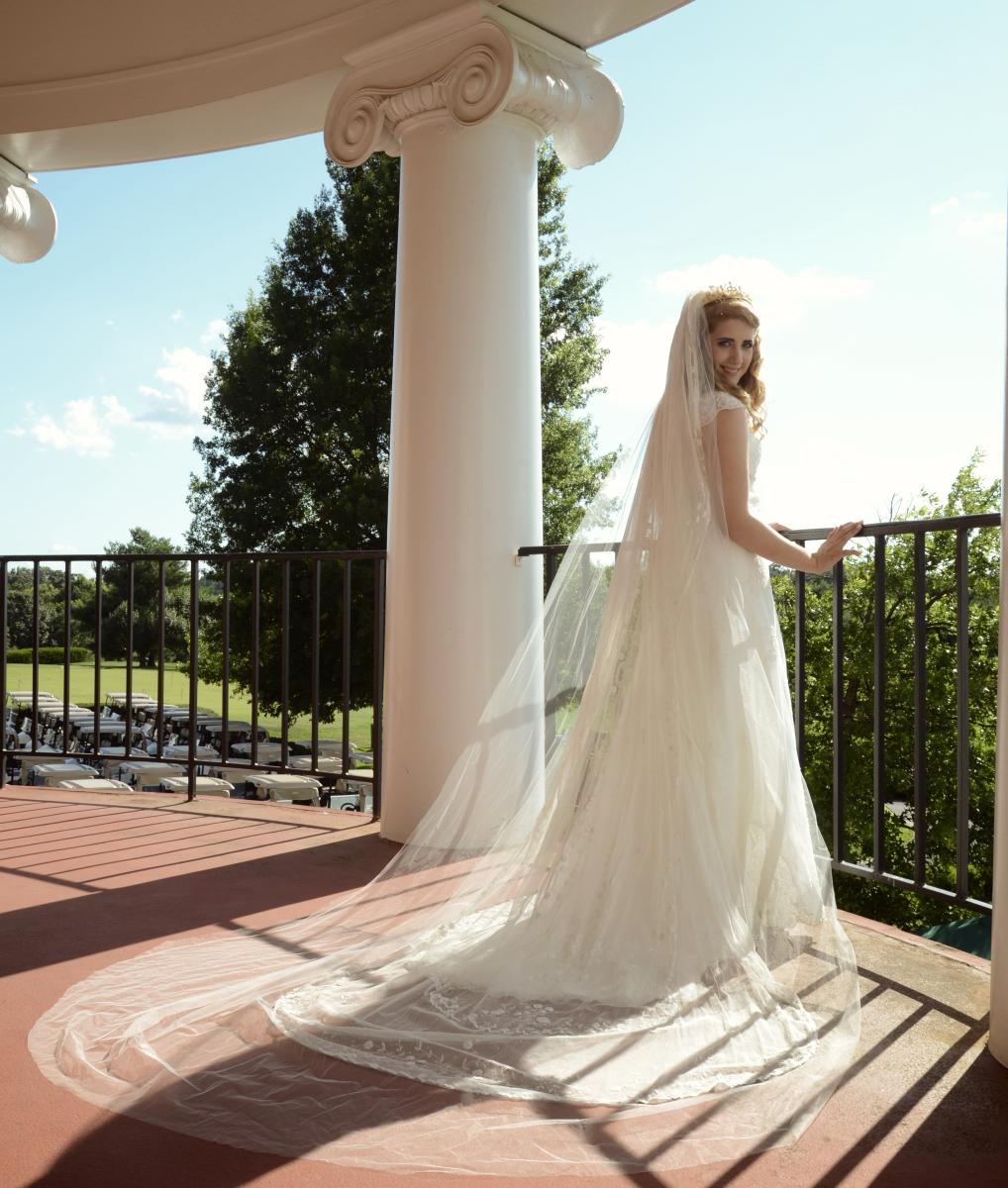 Bride on balcony looking back at photographer at Holly Hills