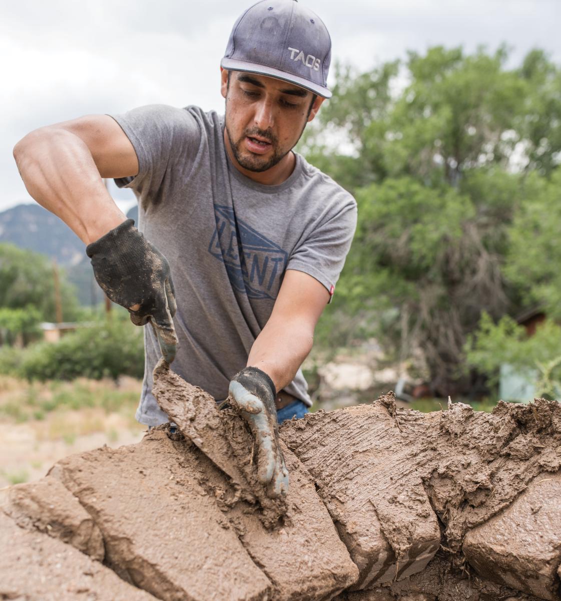 Volunteer Miguel Gonzales helps build Quesa's Farmers' Market horno