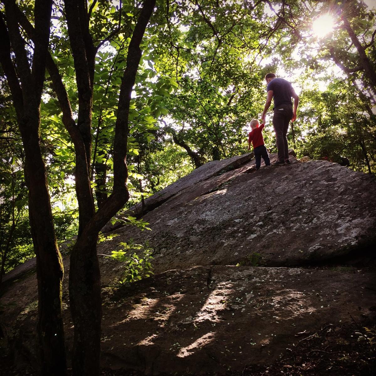 Father and Son Hiking on large rock