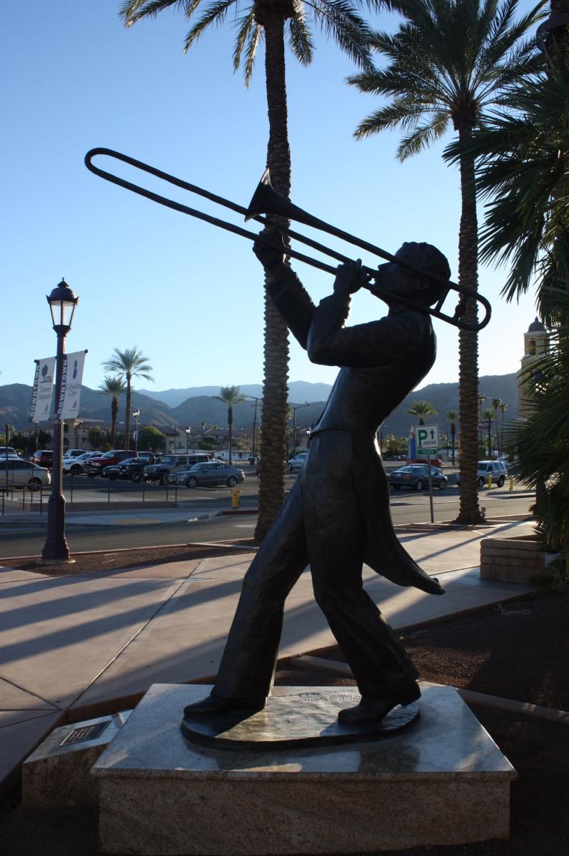 Bronze statue of a man playing a trombone