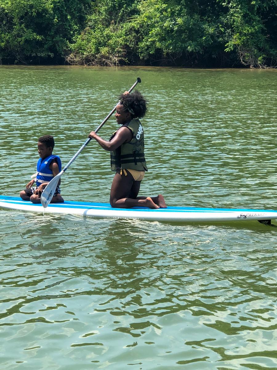 Zenovia Paddleboarding Woman With Child On Paddleboard