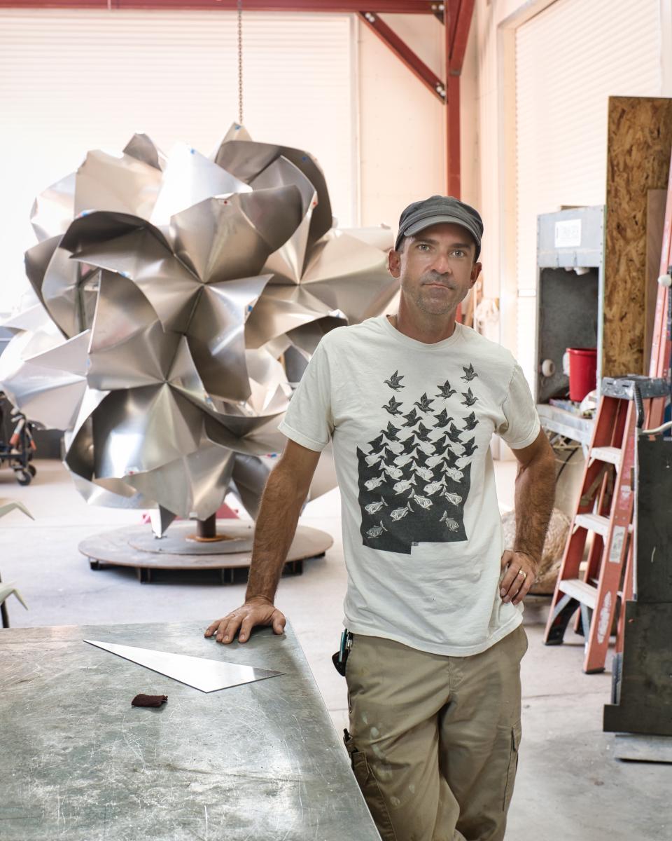 Kevin Box in his studio with Scents of Sincerity, an in-progress aluminum rose, New Mexico Magazine