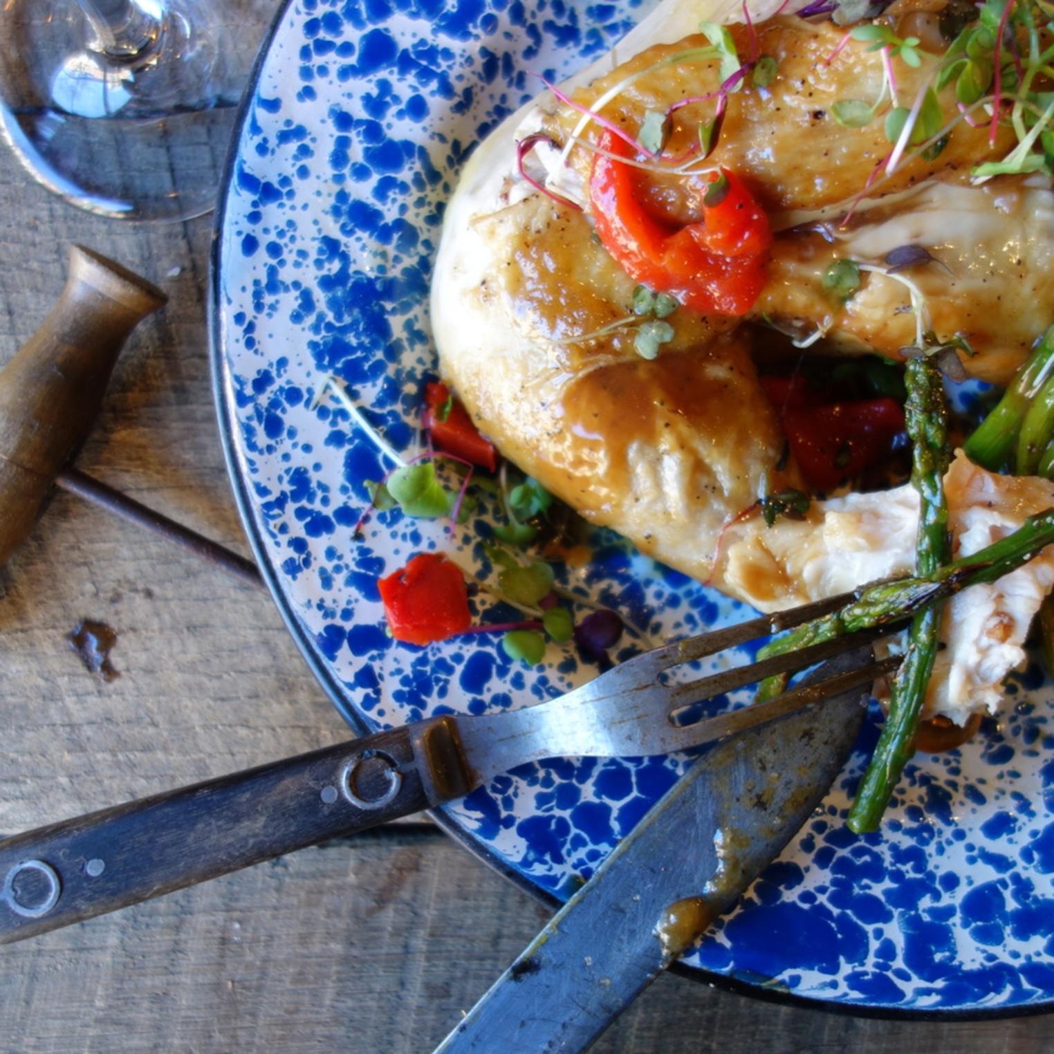 Bourbon Bird is a slow-roasted - local half chicken, served with Sweet Potato Fries.