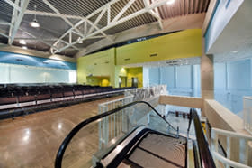Interior photo of Cruise Terminal 21 escalator and passenger seating area