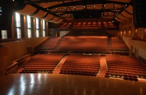 From the stage of the Auer Performance Hall, looking out towards the three seating areas. Large shades cover the north-facing windows during performances.