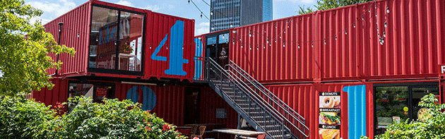 Urban building comprised of red and blue storage containers