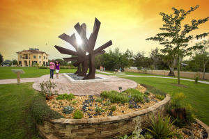 Photo of people at Peace River Botanical and Sculpture Gardens.  In foreground "Steel Palm" sculpture