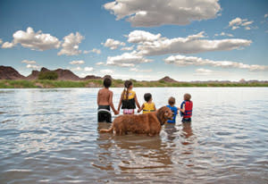 kids in river with dog