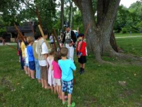 Young attendees at the Siege of Fort Wayne listen to instructions from a costumed interpreter