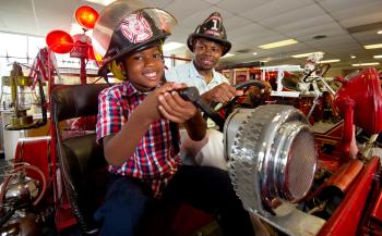 A boy and his father enjoy one of the interactive exhibits at the Vintage Fire Museum.