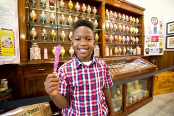 A boy happily shows his candy in Schimpff’s Confectionery.