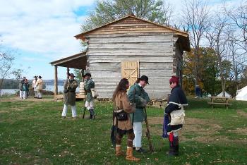 A group outside of the George Rogers Clark historical home in period costume.