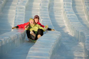 a boy and girl sledding on a mega ice slide