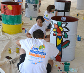 Photo of participants wearing Shipshape t-shirts painting a recycled petroleum barrel.