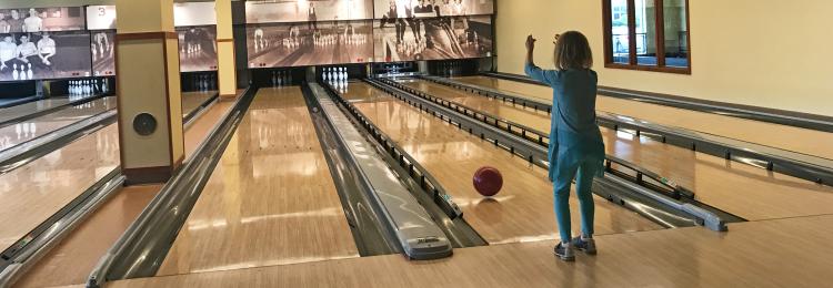 Little girl bowling at Pinstripes in Overland Park