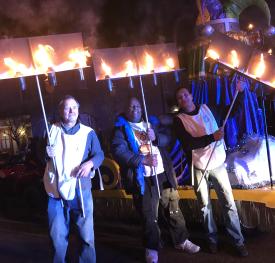 A group holds up their Flambeaux torches for Mardi Gras celebrations in Covington