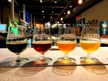 Flight of various beers on bartop counter at Columbus Brewing Company's updated taproom