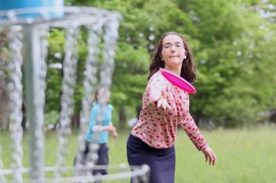 Girl throwing frisby at Jewish Discovery Center