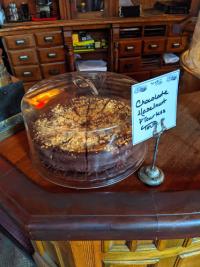 photo of cake under a cake dome with sign that says chocolate hazelnut flourless torte at york street cafe in newport ky