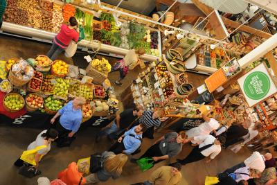 Birds-eye view of people shopping amongst colorful produce in North Market