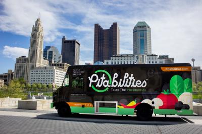 Pitabilities food truck in front of city skyline under blue sky