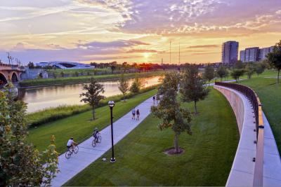 Aerial view of people riding bikes on path along river during sunset at the Scioto Mile