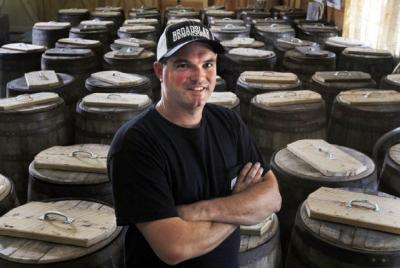 Broadslab Distillery's owner and distiller, Jeremy, standing in front of barrels of moonshine, Johnston County, NC.