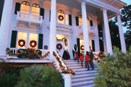 Family walking up the steps at Bellamy Mansion at Christmas