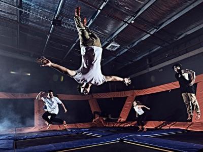 People jumping and flipping on trampolines inside Sky Zone