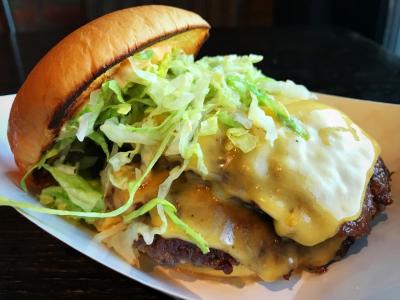 Burger from Preston's Burgers topped with lettuce, cheese, and two patties